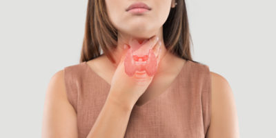 Women thyroid gland control. Sore throat of a people on gray background